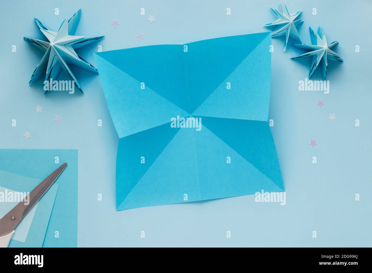 Semplice albero di Natale 3D origami fatto di carta blu. Istruzioni passo a  passo, passo 6. Distendere il foglio e capovolgerlo nuovamente. Premere il  centro per ruotare le pieghe Foto stock - Alamy