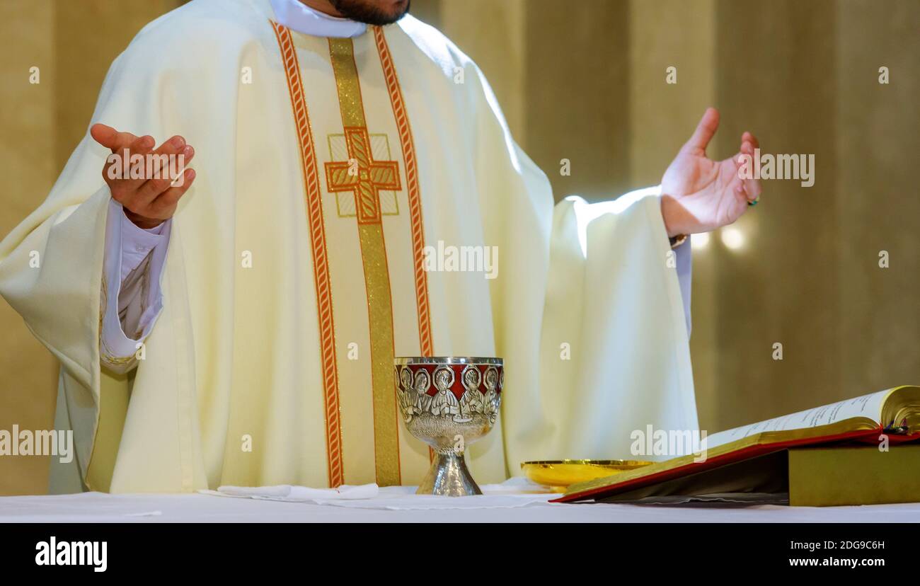 Santa comunione su tavola di legno in calice di chiesa con vino rosso, pane, preghiera per il vino Foto Stock