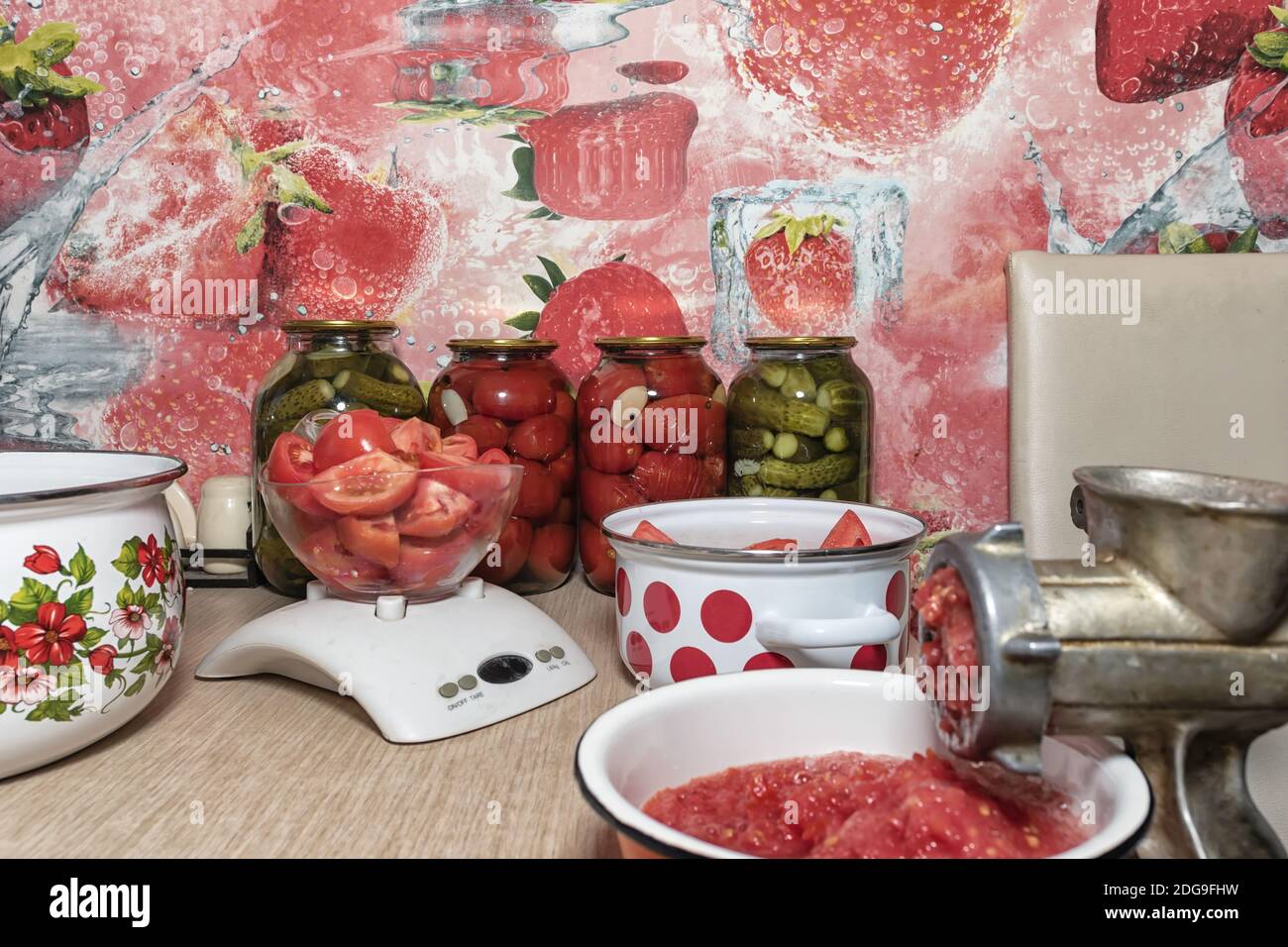 Torcere i pomodori in purea di pomodoro con un vecchio macinacaffè Foto Stock