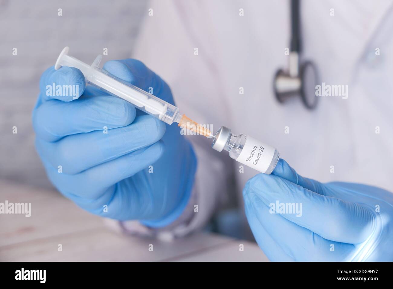 Il medico le mani in guanti medici tiene la siringa e il vaccino. Foto Stock