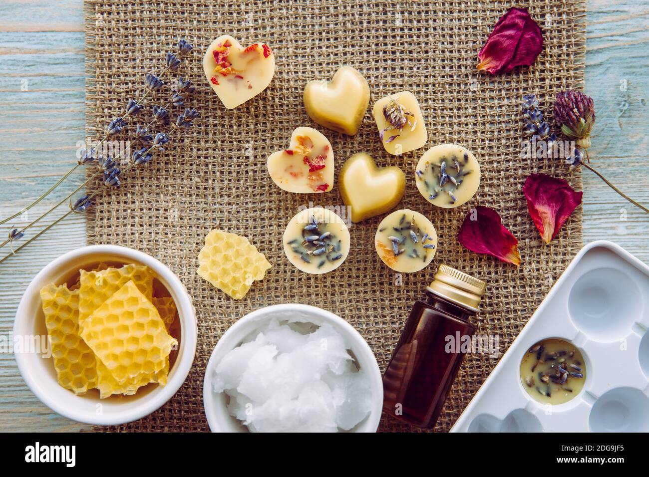 La realizzazione di mini cera fonde per diffusore di lampade aromatiche a casa concetto. Strumenti ingredienti sulla tavola cera d'api greggi, olio di cocco solido, olio essenziale. Foto Stock