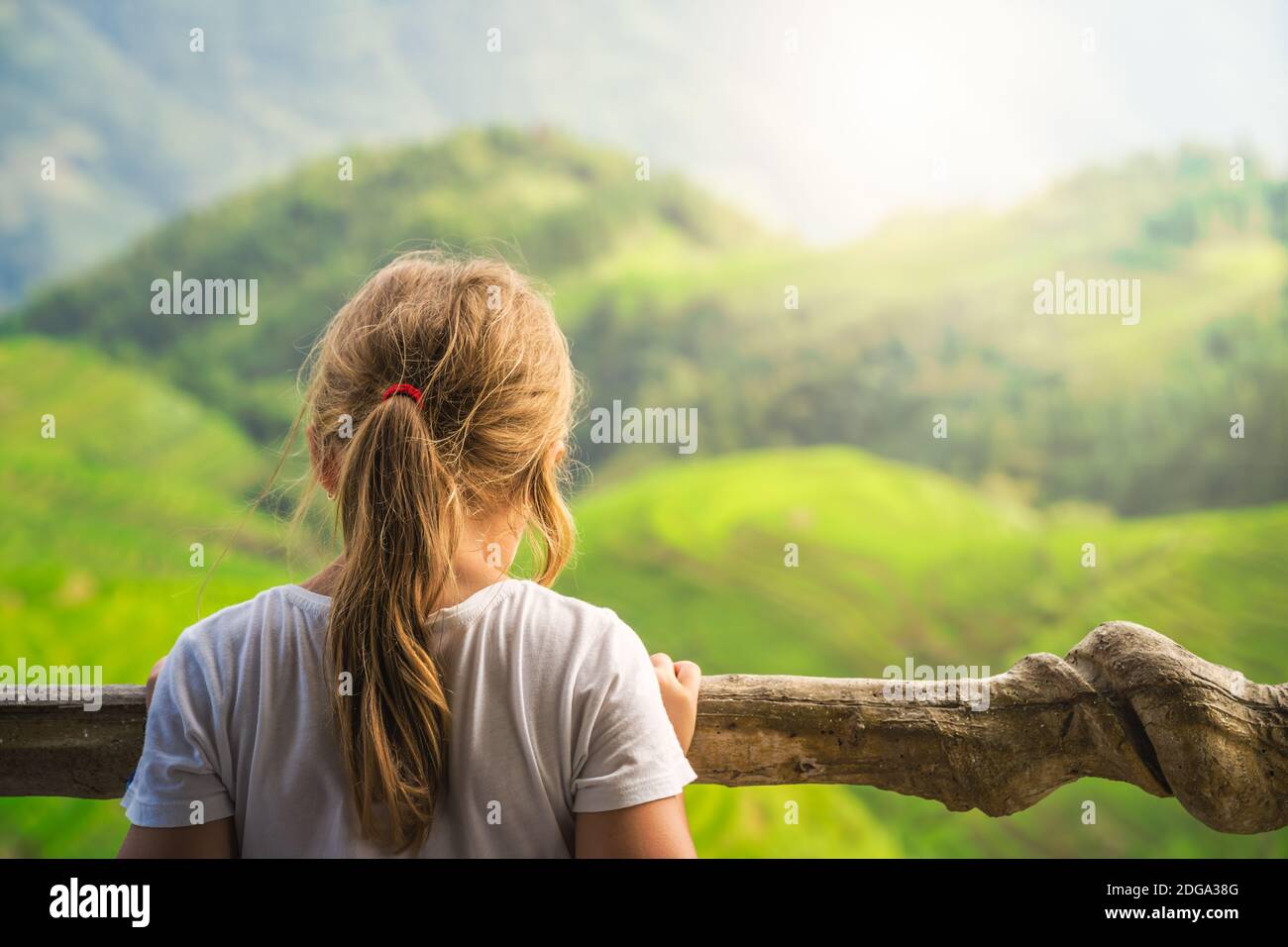 Carina giovane ragazza in piedi su un punto di osservazione nove draghi e cinque tigri e ammirando le cascate a strati Longji Rice terrazze, Pingan villaggio, GUI settentrionale Foto Stock