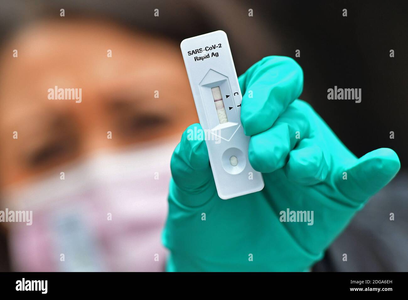 Monaco, Germania. 06 dicembre 2020. Immagine dell'argomento Test antigene corona. Una giovane donna indossa guanti verdi in lattice e sta facendo un test corona rapido. MODELLO RILASCIATO! | utilizzo in tutto il mondo credito: dpa/Alamy Live News Foto Stock