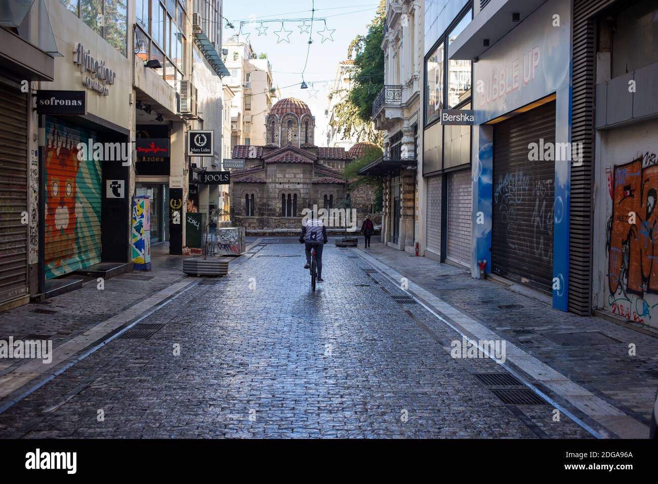 Centro di Atene, Grecia. 5 Dicembre 2020. Biker su via vuota Ermou, giorno d'inverno. I negozi sono chiusi, COVID 19 blocco pandemico Foto Stock