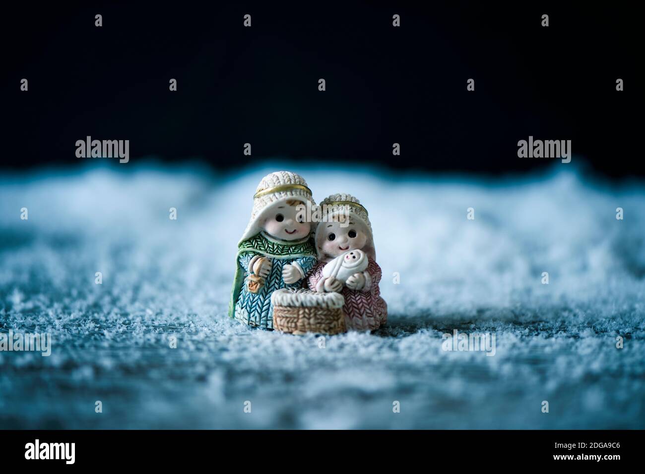 la santa famiglia, il bambino gesù, la vergine maria e san giuseppe, sulla neve su sfondo nero con qualche spazio vuoto in cima Foto Stock