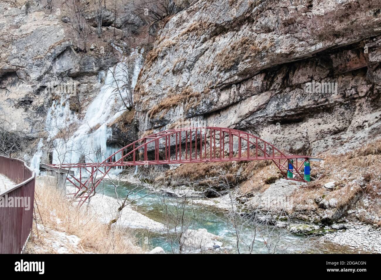 Semplice ponte di metallo su un fiume di montagna ruvido nel regione montagnosa Foto Stock
