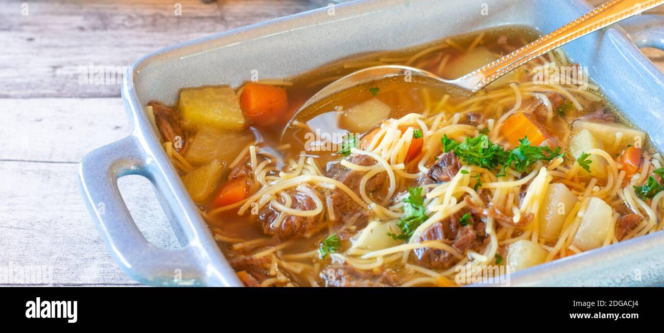 Sfondo Banner imange con una ciotola di zuppa di noodle di manzo con cucchiaio Foto Stock