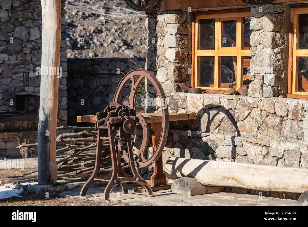 Restaurato rifugio Balkar fatto di grandi pietre e legno con macchina per la lavorazione della lana Foto Stock