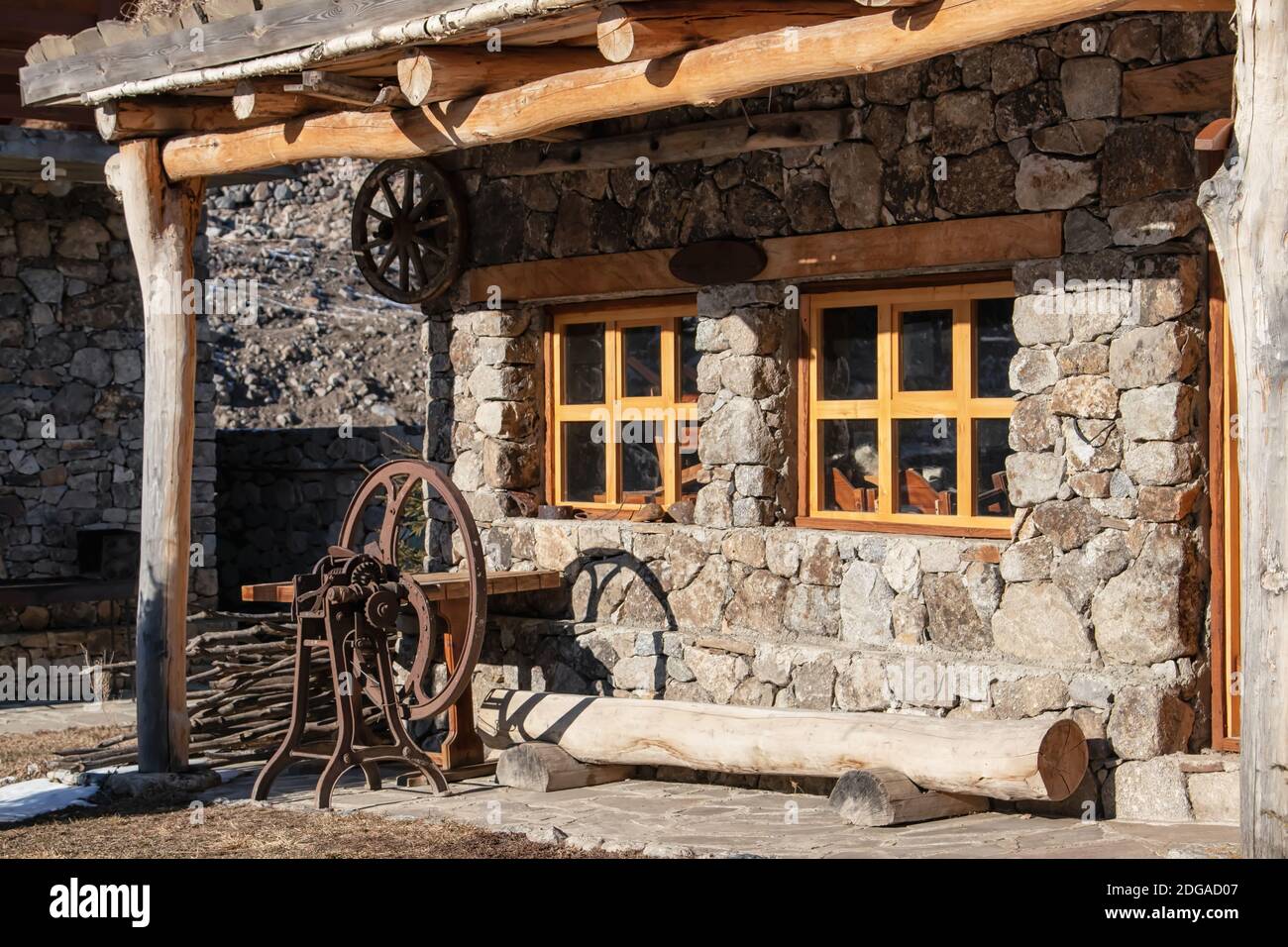 Restaurato rifugio Balkar fatto di grandi pietre e legno con macchina per la lavorazione della lana Foto Stock