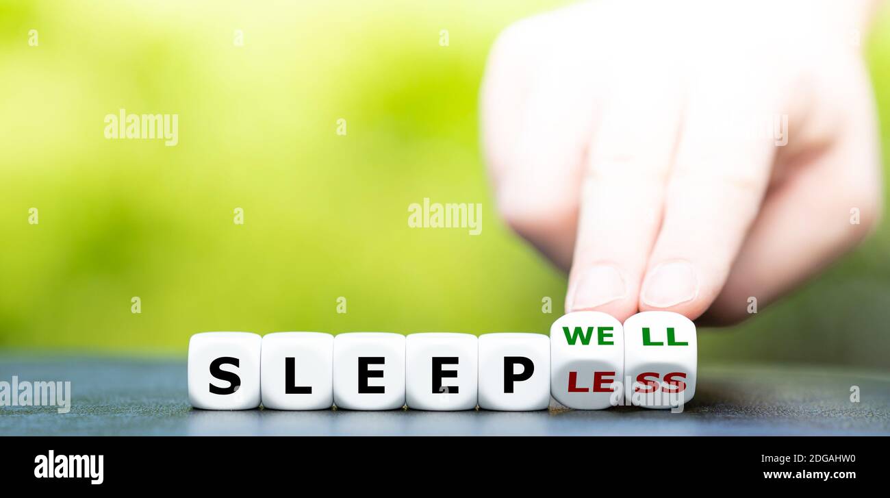 La mano trasforma i dadi e cambia l'espressione "leepless" in Dormi bene. Foto Stock