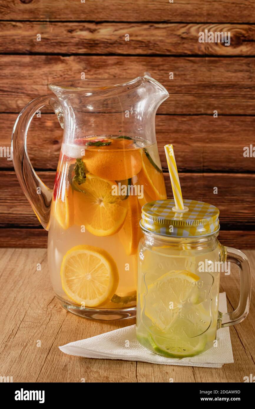 Grande caraffa di vetro con acqua aromatizzata agli agrumi e limonata fatta  in casa. Bicchiere o barattolo con bevanda, coperchio e paglia. Freschezza,  salute e non alcolicità Foto stock - Alamy