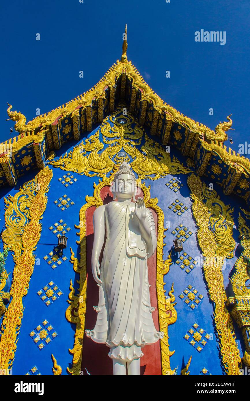 Bella scultura di buddha bianco fuori della chiesa di Wat Rong su Ten, Chiangrai, Thailandia. Statua bianca del Buddha all'aperto a Wat Rong su Ten, temperatura blu Foto Stock