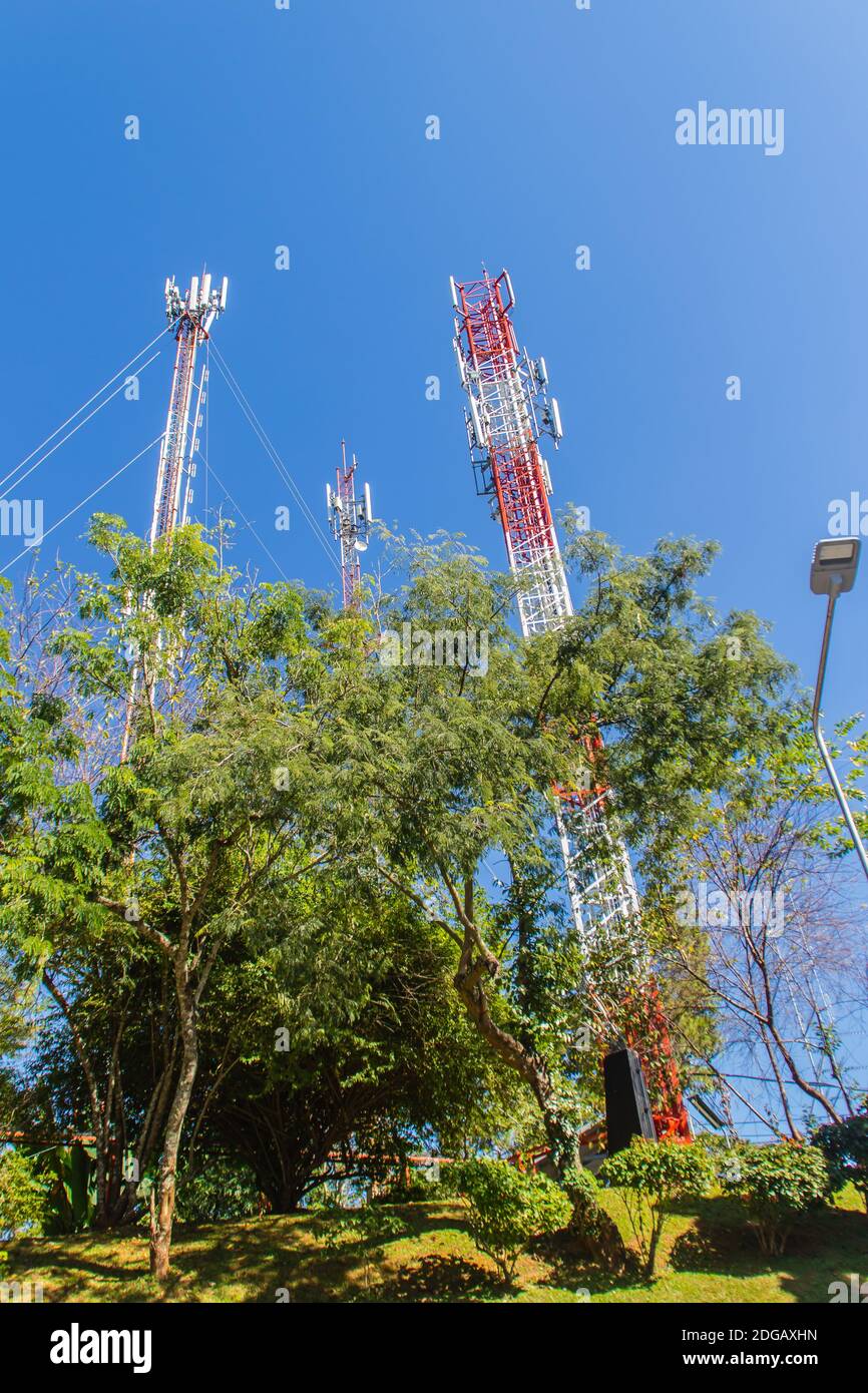 Alto telefono cellulare e torri di comunicazione su sfondo blu cielo. Alta torre di telecomunicazioni su sfondo blu cielo vuoto. Torre GSM utilizzata per tra Foto Stock
