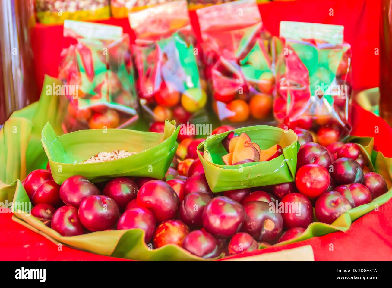 I frutti rossi di ramontchi (Flacourtia indica) in vendita sul mercato locale di Chiang Rai, Thailandia. Flacourtia indica nota anche come ramontchi, la p del governatore Foto Stock