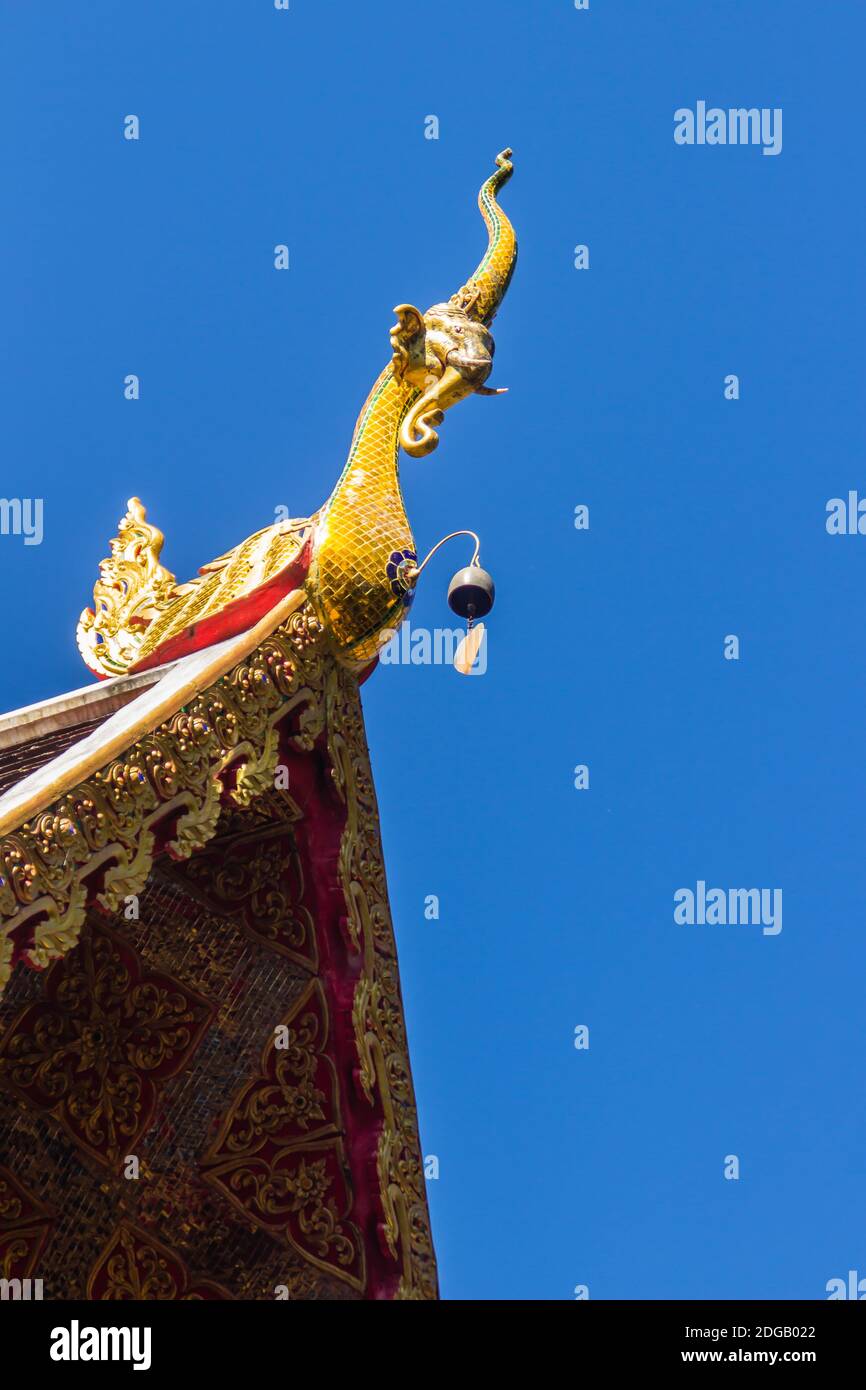 Belle sculture dorate di naga sul tetto della chiesa sotto lo sfondo blu del cielo a Wat Phra che Doi Tung, uno dei quali si ritiene contenere l Foto Stock