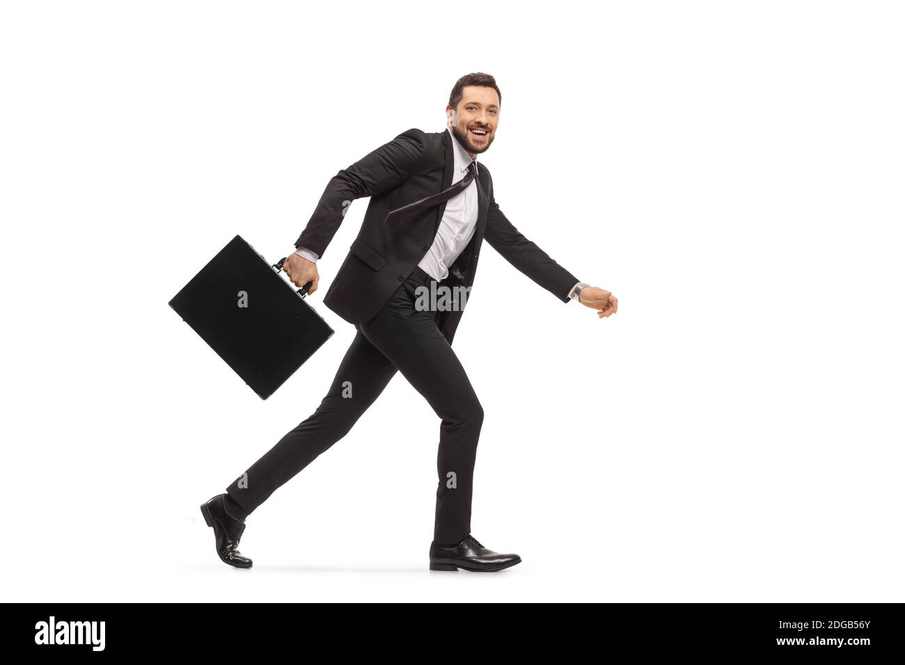 Uomo d'affari in un vestito nero che corre e guarda la macchina fotografica isolato su sfondo bianco Foto Stock