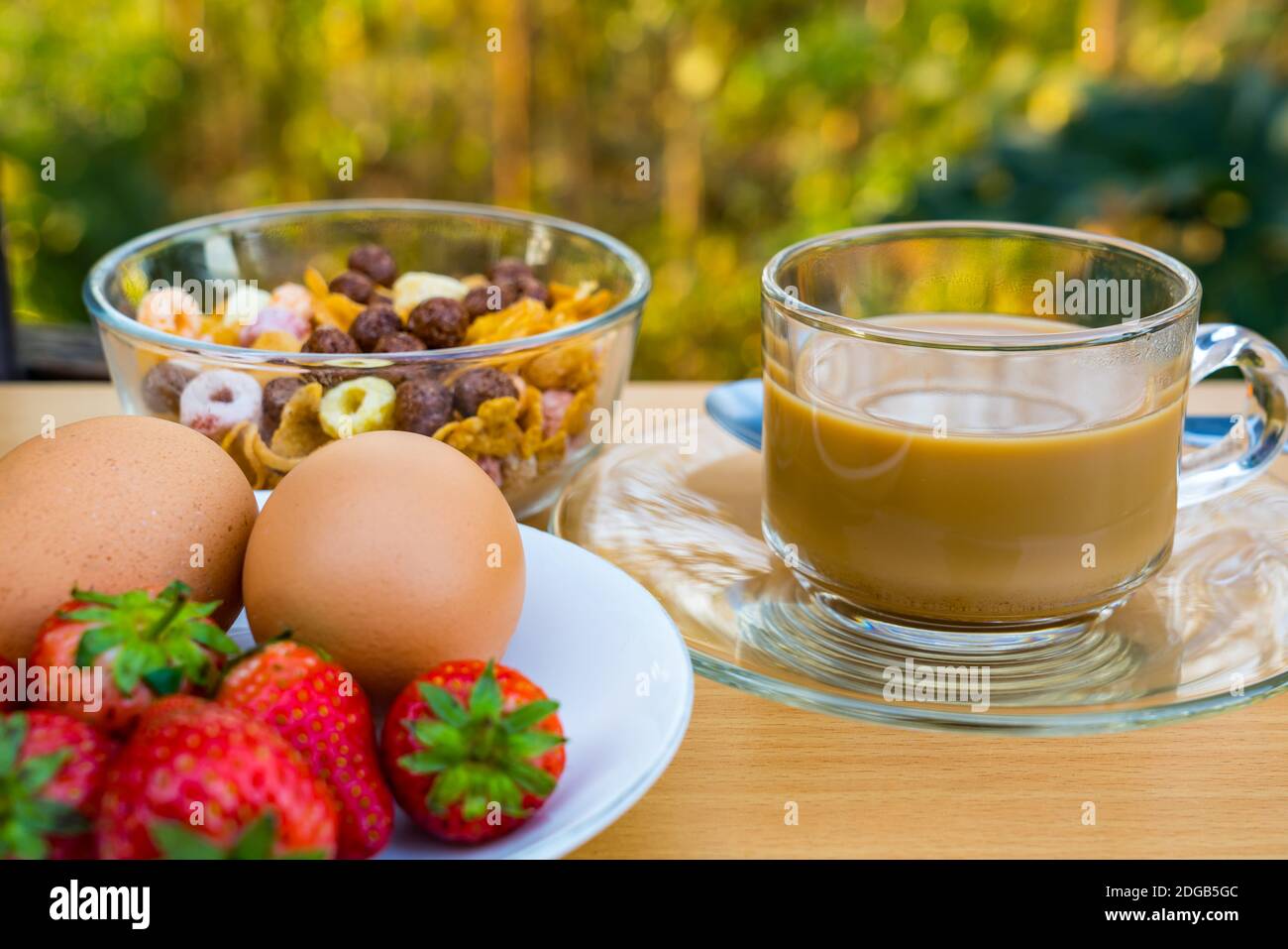 Caffè caldo, cornflekes, uova bollite e fragola matura Foto Stock