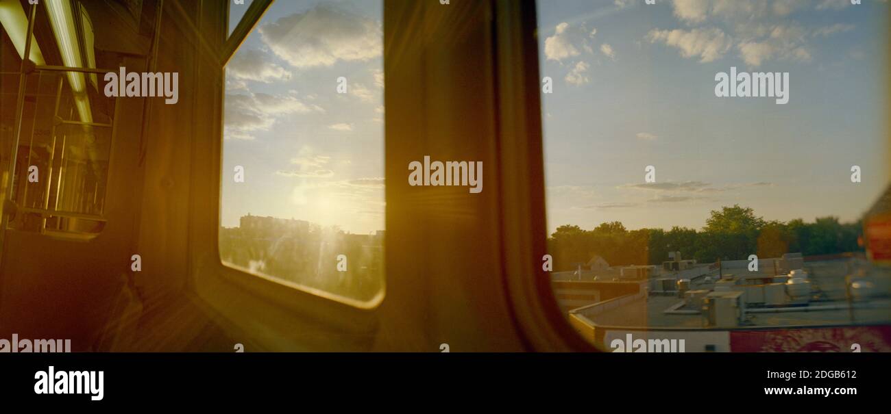 Città vista dalla finestra del treno al tramonto, Cook County, Illinois, USA Foto Stock