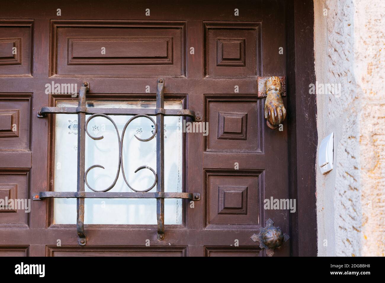 finestra nella porta incorniciata da una griglia di finestra. Medinaceli, Soria, Castilla y León, Spagna, Europa. Foto Stock