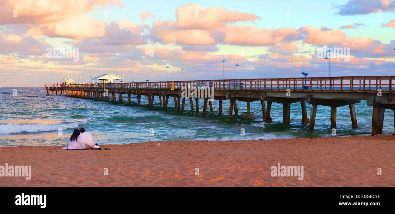 Coppia seduta sulla spiaggia al tramonto, Fort Lauderdale, Florida, USA Foto Stock