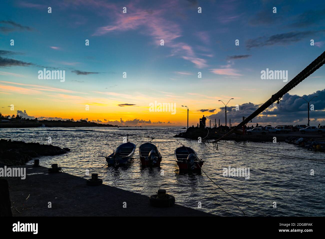 Silhouette del porto di pescatori di Hanga Roa Village al tramonto In Isola di Pasqua Foto Stock