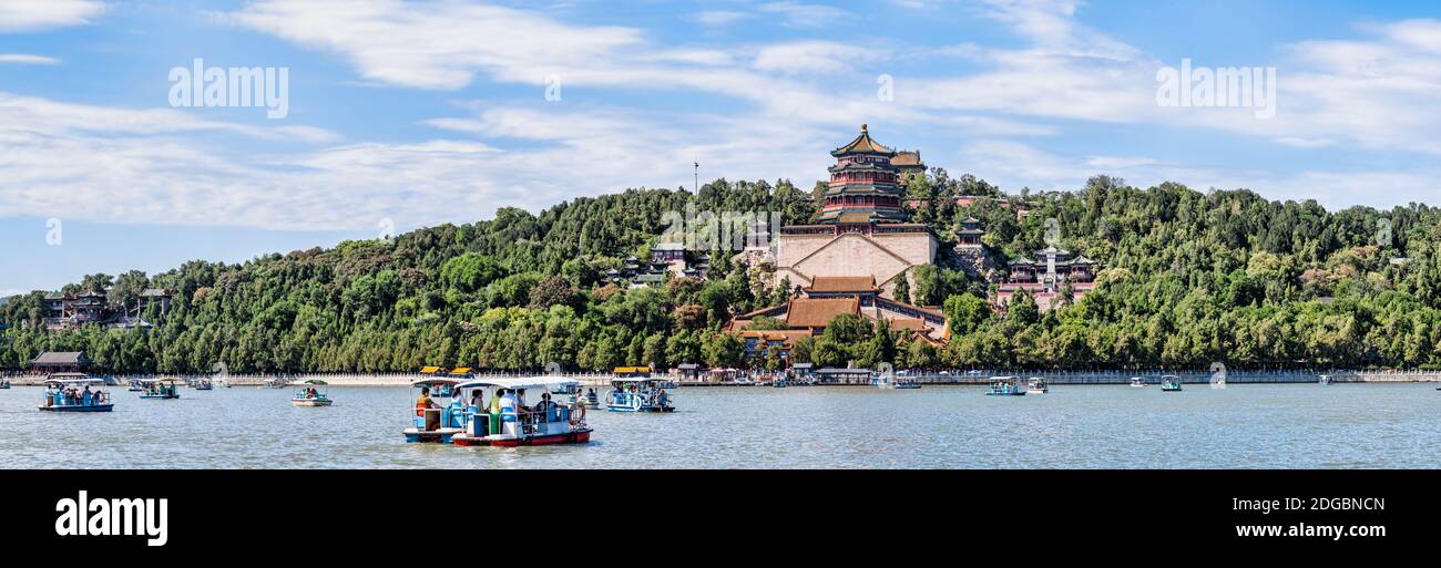 Turisti in barca in un lago con un palazzo sullo sfondo, Palazzo d'Estate, Lago Kunming, Pechino, Cina Foto Stock