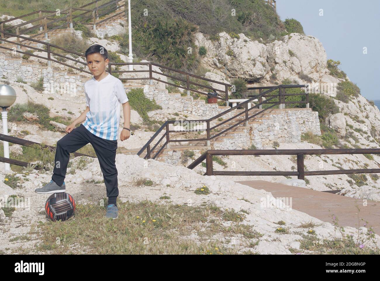 Ragazzo che gioca a calcio all'aperto Malaga, Andalusia, Spagna Foto Stock