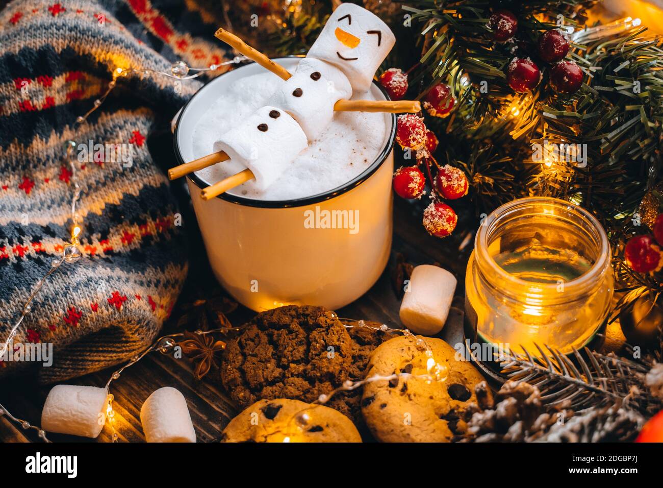 Tazza bianca di cibo di Natale con marshmallows di pupazzo di neve al cioccolato caldo. Biscotti fatti in casa, bastoni di cannella rami di abete xmas con luci calde di ghirlanda. Est Foto Stock