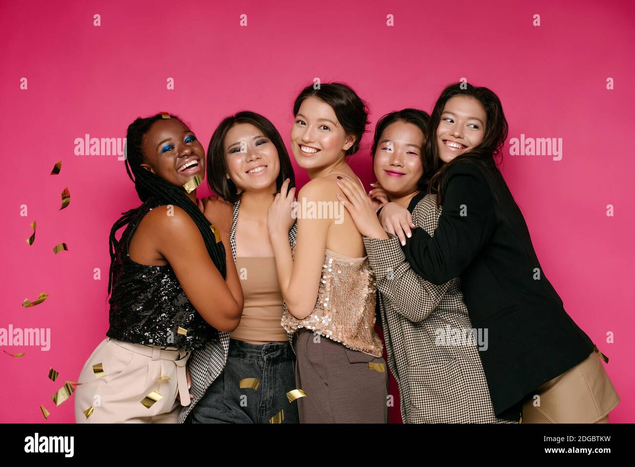 Ritratto di cinque belle donne con i confetti d'oro che cadono intorno loro Foto Stock