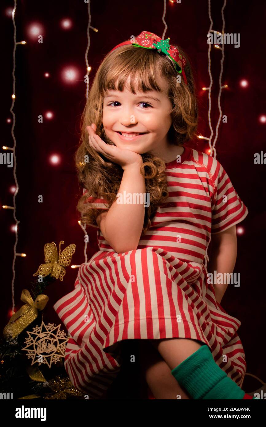 Ritratto di una ragazza sorridente davanti alle luci di Natale Foto Stock