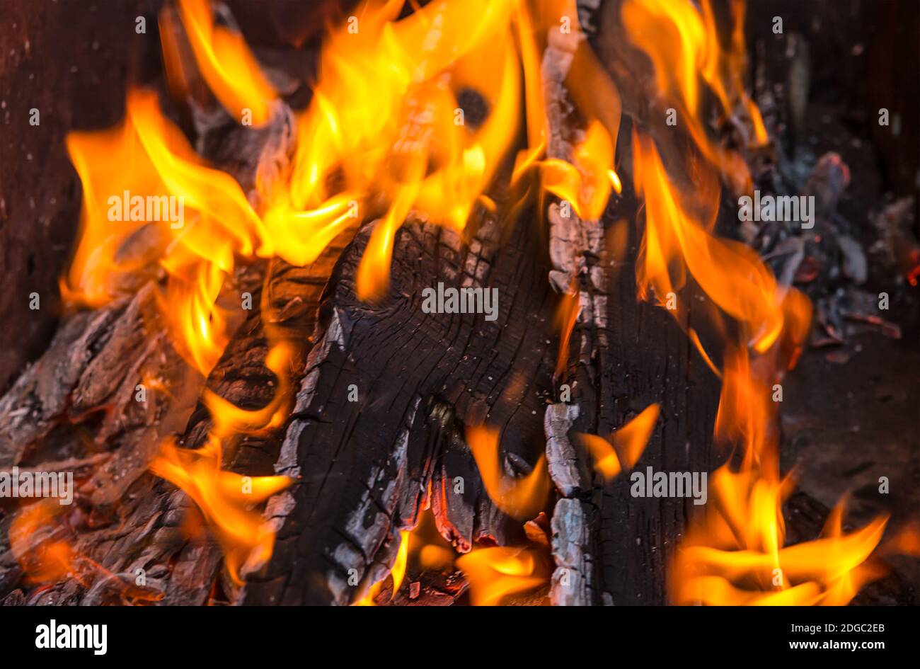 La fiamma arancione perfora i pannelli bruciati fuoco luminoso da vicino Foto Stock