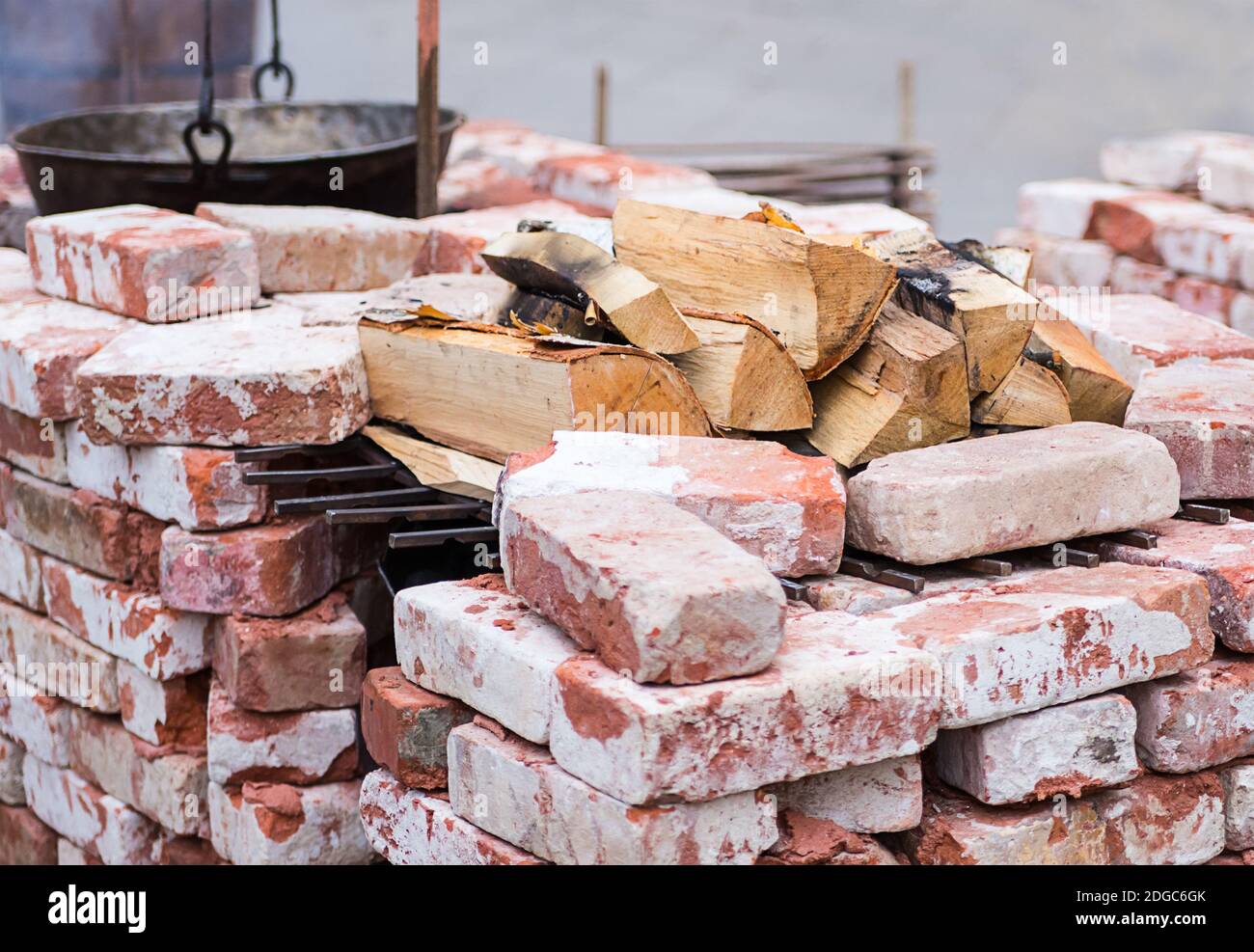 Braciere ripiegato di mattoni in calce, resistente al calore con un stock di legna da ardere di betulla e una pentola Foto Stock
