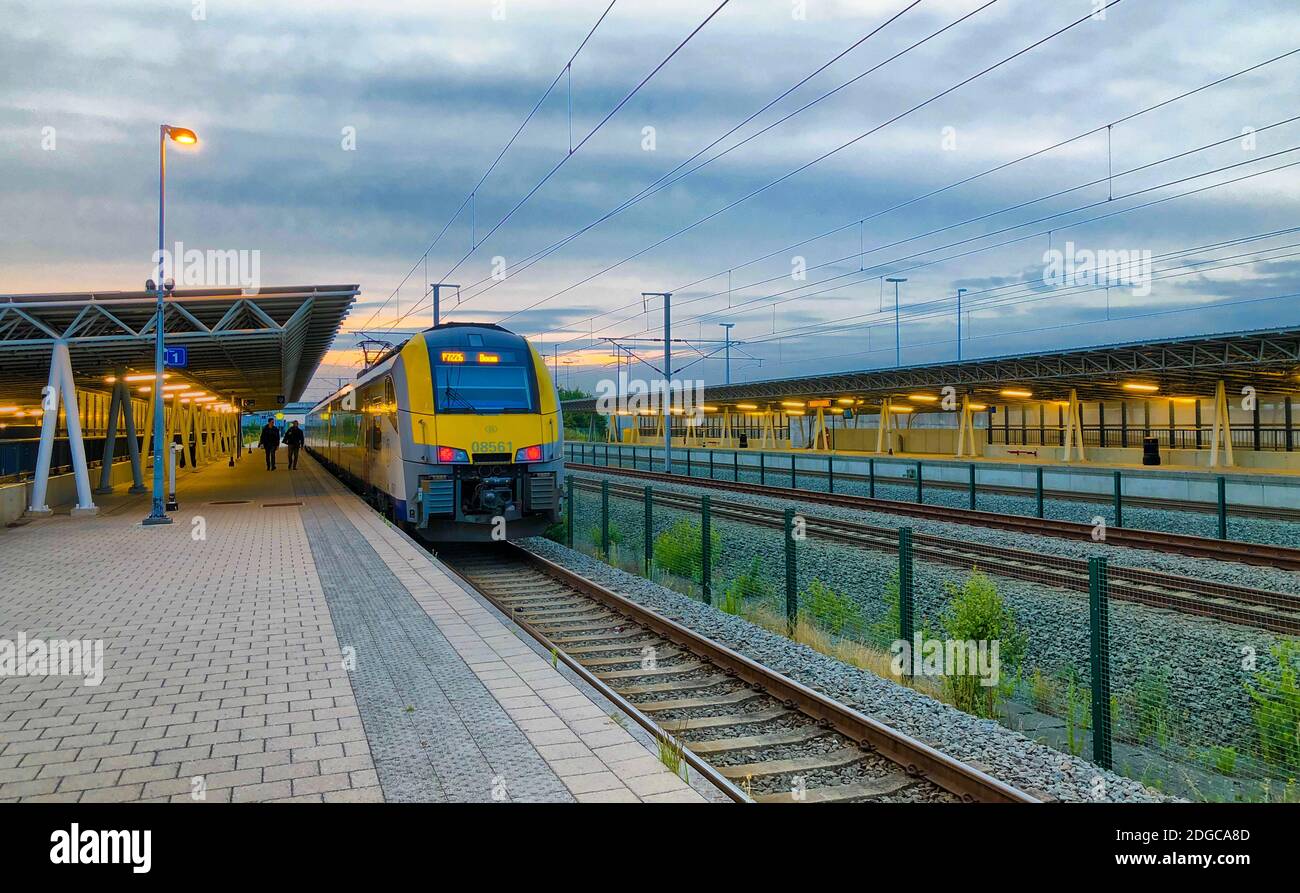 Brecht, Belgio - Giugno 2019: Un treno per pendolari alla stazione ferroviaria di Noorderkempen a Brecht all'alba Foto Stock