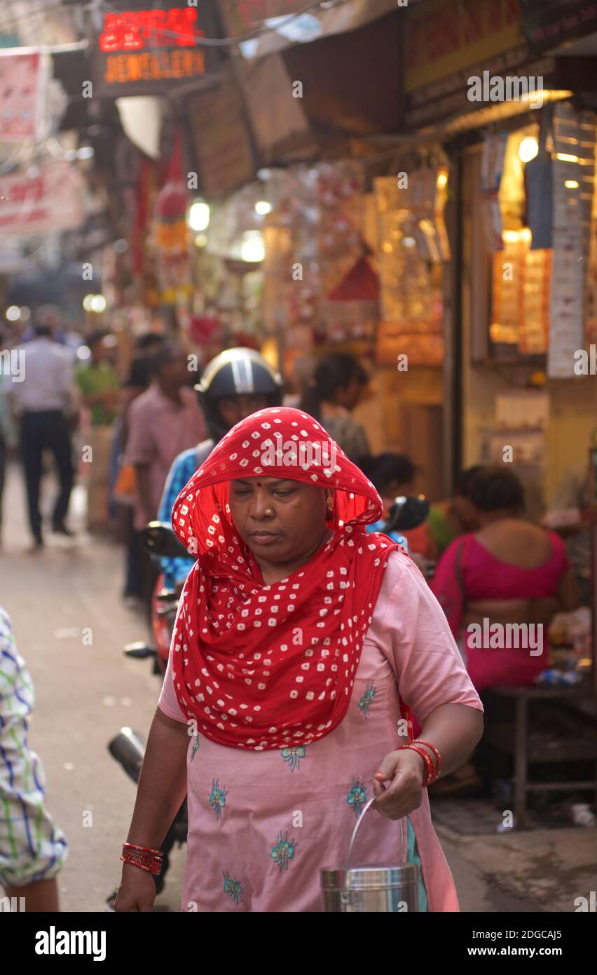 Donna indiana fuori shopping nelle strade strette affollate di Chandi Chowk zona di mercato, Old Delhi, India Foto Stock