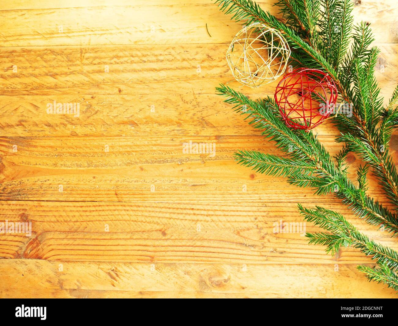 Sfondo di Natale in legno con un ramo di abete e baubles di Natale Foto Stock