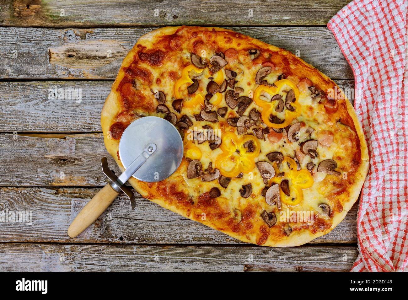 Pizza di funghi fatta in casa con taglierina e asciugamano. Foto Stock