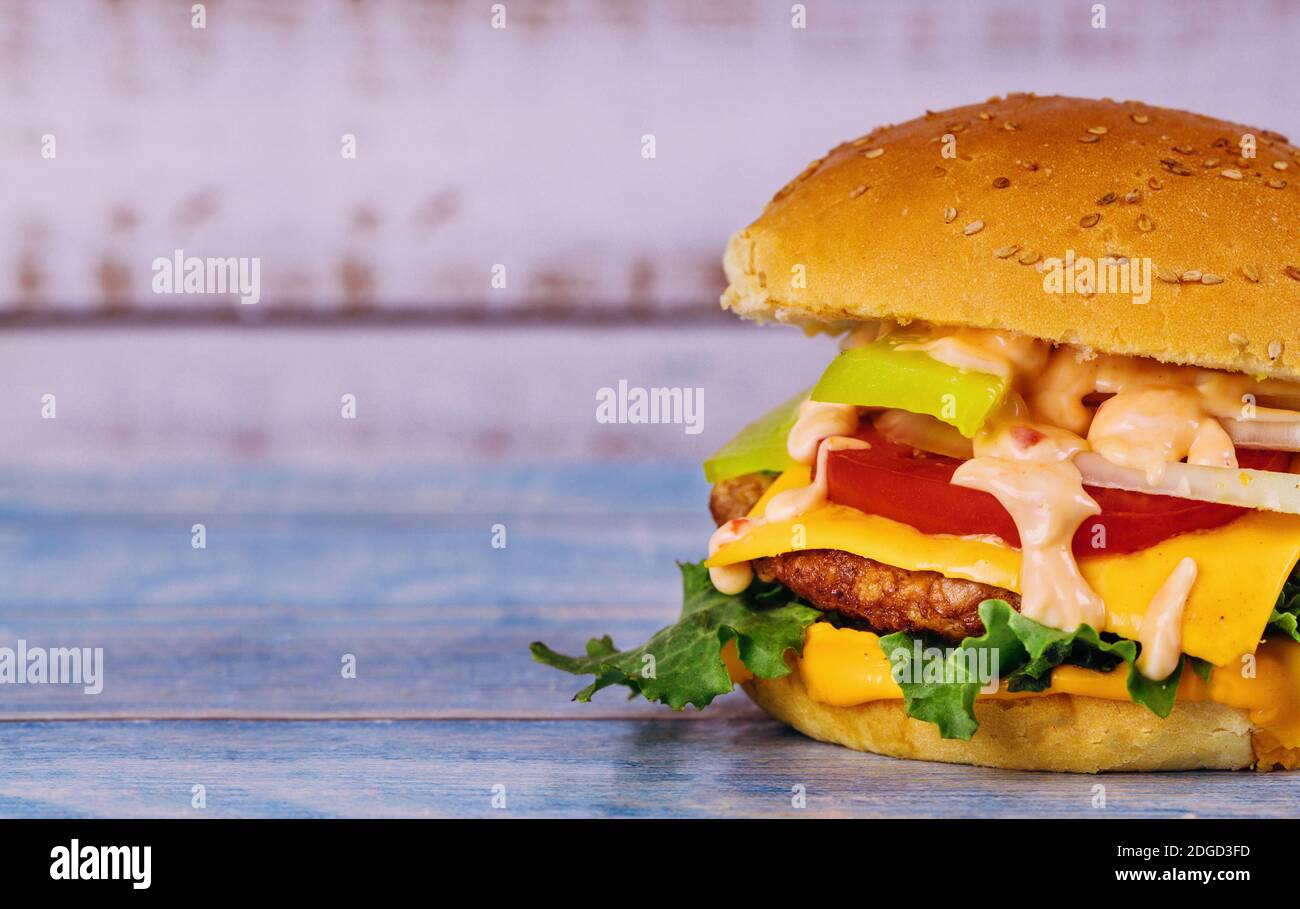 Cheeseburger con formaggio fuso su un tavolo bianco. Foto Stock