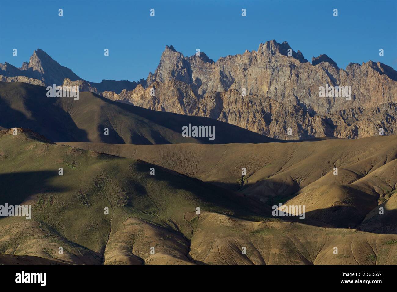 La luce del sole di mattina illumina le cime di montagna accanto alla strada Leh a Srinagar vicino Lamayoiro, Ladakh, Jammu e Kashmir, India Foto Stock