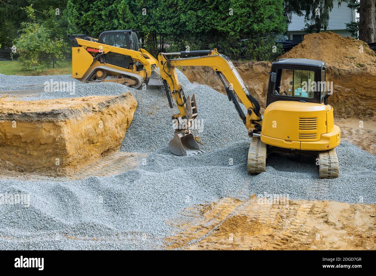 Un bulldozer su ruote backfill di lavori di fondazione sul cantiere per l'edificio in costruzione. Foto Stock