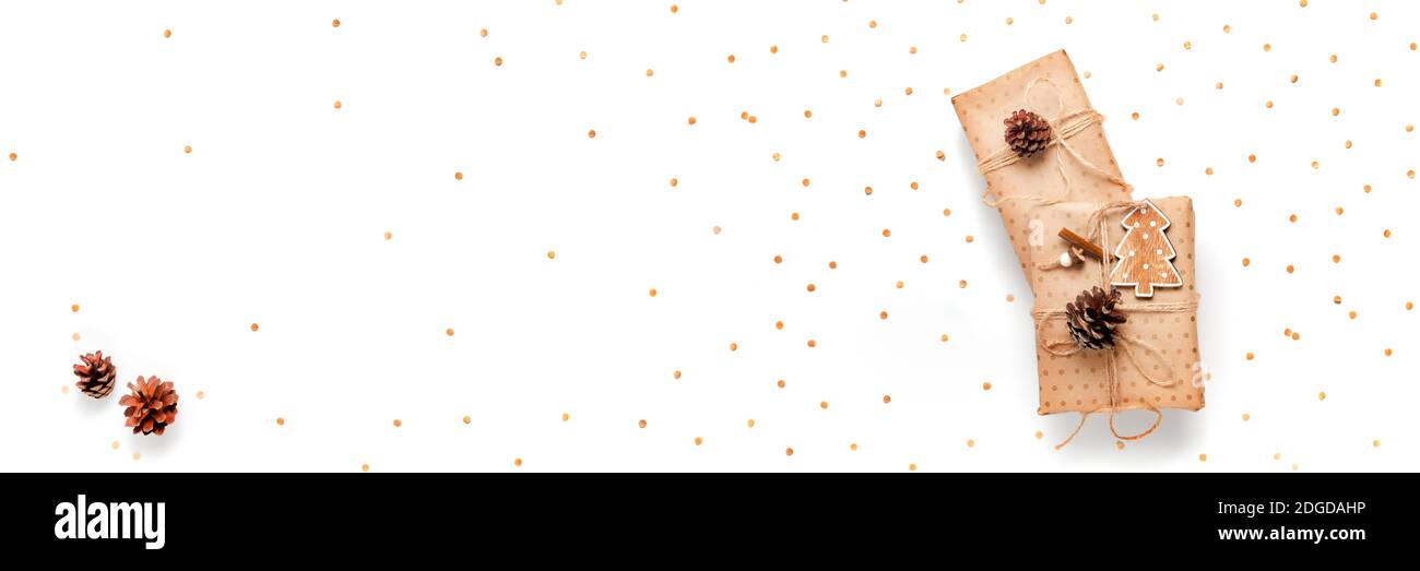 Confezione regalo avvolta in carta artigianale decorata con cono di pino su sfondo bianco, banner lungo, spazio copia, vista dall'alto Foto Stock