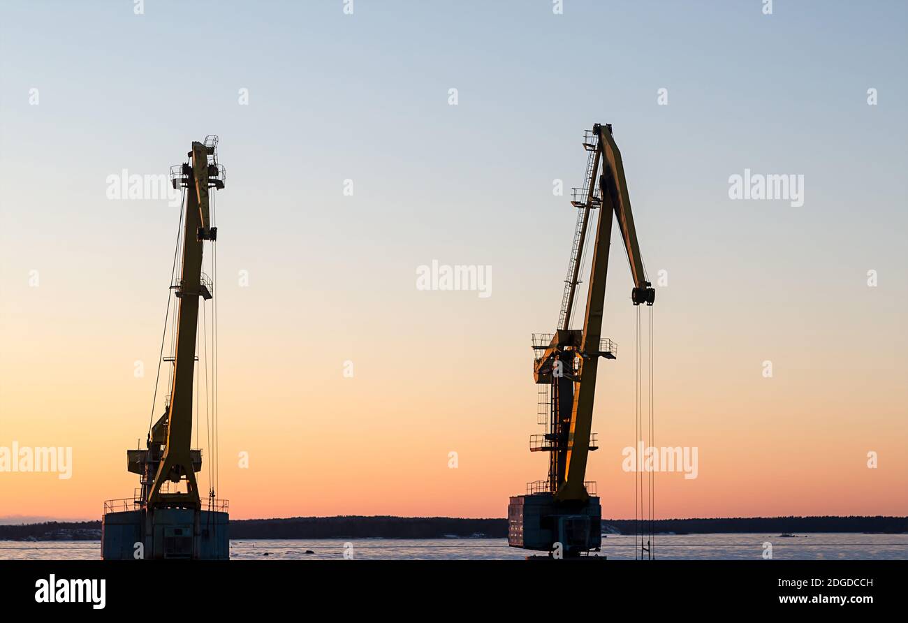 Gru porto tramonto sfondo. Background industriale potenti macchine per il trasporto di oggetti, merci Foto Stock