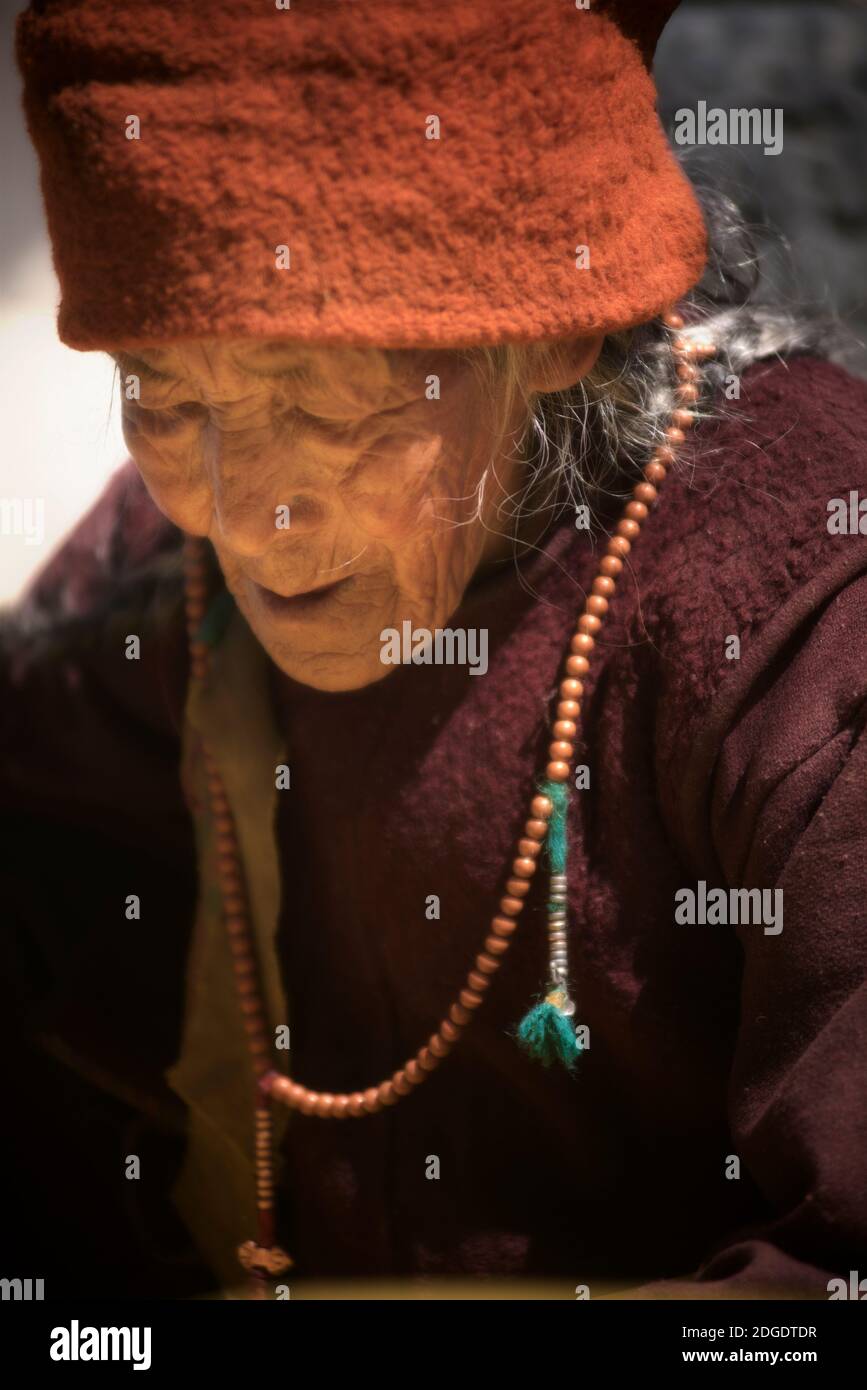 Anziana donna Zanskari in abbigliamento tradizionale. Sulla Zanskar Valley Road da Padum a Zangla. Ladakh, Jammu e Kashmir, India settentrionale Foto Stock