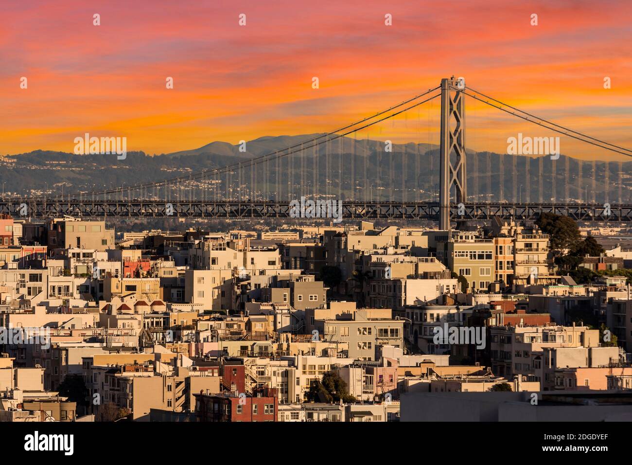 San Francisco case in collina e l'Oakland Bay Bridge con il cielo del tramonto. Foto Stock