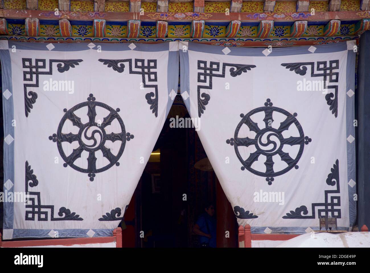 Sullo schermo in tessuto all'ingresso della sala di preghiera del monastero di Hemis si trova il Dharmachakra - una tipica ruota del Dharma con 8 raggi che rappresentano il Sentiero dell'Eight - il simbolo più antico e universale per il Buddismo. Monastero di Hemis, Hemis, Ladakh, Jammu e Kashmir, India. Foto Stock