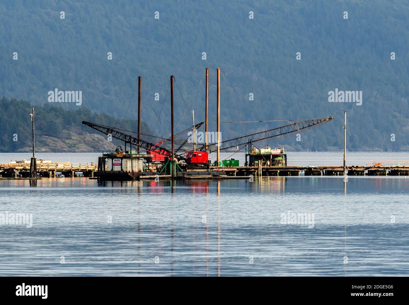 gru industriali su lavoro su molo oceanico Foto Stock