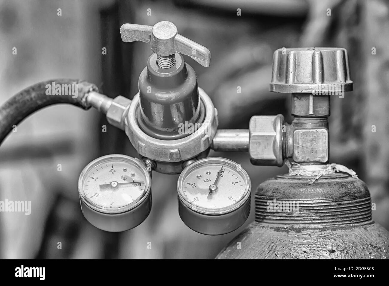Riduttore in ottone con due manometri avvitati sul cilindro con gas compresso Foto Stock