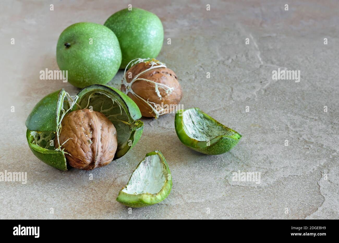 Noci comuni in guscio verde sul tavolo Foto Stock