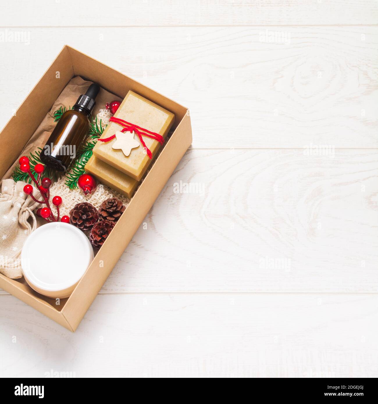 Bella scatola presente con cosmetici biologici su sfondo di legno. Vetro, decorazioni in legno. Zero rifiuti Natale concetto. Disposizione piatta, vista dall'alto Foto Stock