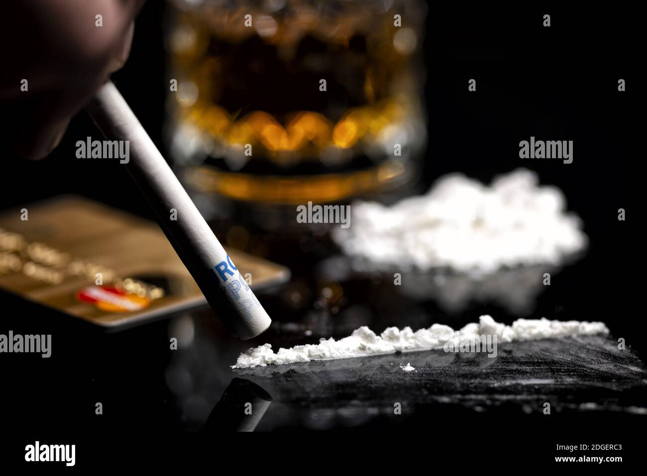 Linea di cocaina, carta di credito e vetro con rum Foto Stock