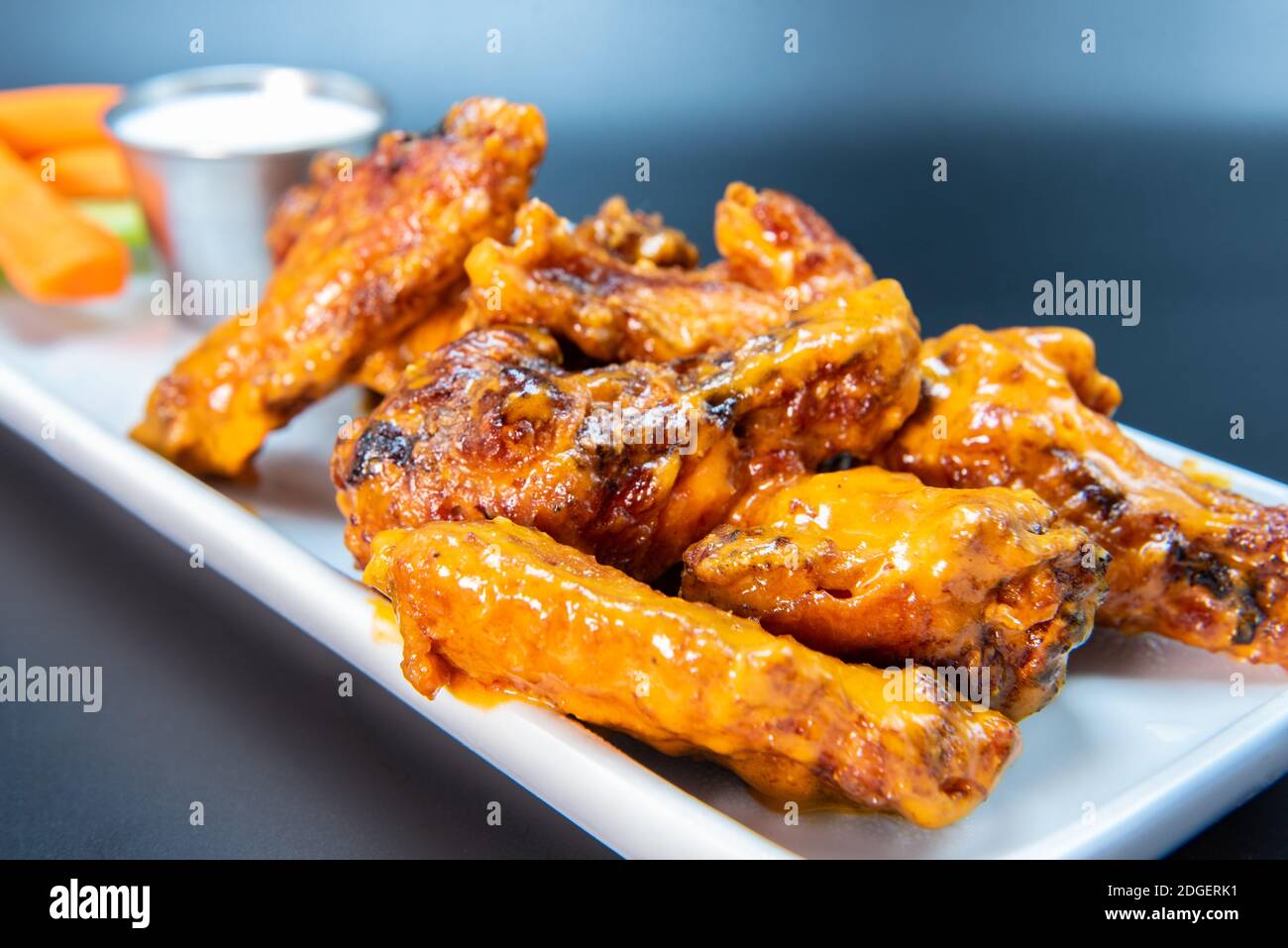 Le deliziose ali di pollo piccanti e dolci accatastate su un piatto fanno crescere l'acqua della bocca e lo stomaco. Foto Stock